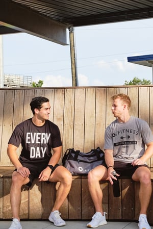 two men wearing O2 Fitness shirts