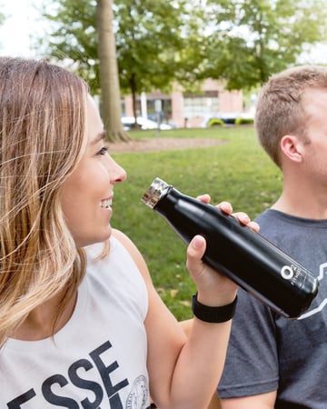 woman drinking from O2 Fitness water bottle