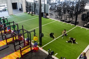 women stretching on the indoor functional training turf area
