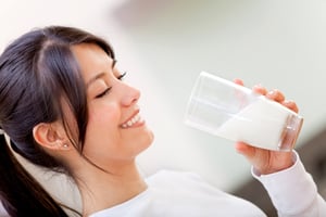 Beautiful woman drinking milk and then smiling