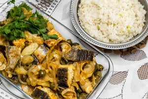Delicious and traditional portuguese codfish with potatoes and a plate with rice