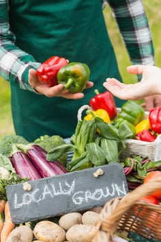 Farmer selling organic peppers at a farmers market