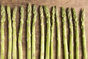 Fresh raw asparagus on a wooden kitchen work surface