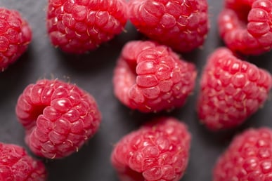 Fresh ripe summer raspberries on black slate