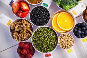 Portion cups and spoons of healthy ingredients on wooden table