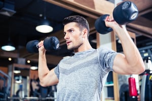 Portrait of a fitness man workout with dumbbells at gym
