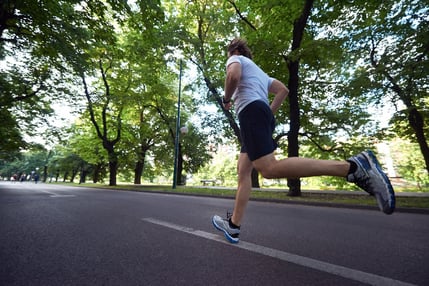 healthy athlete man jogging at morning on empty  roat in the city