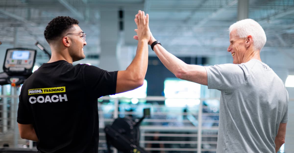 Personal trainer high fiving client over progress made