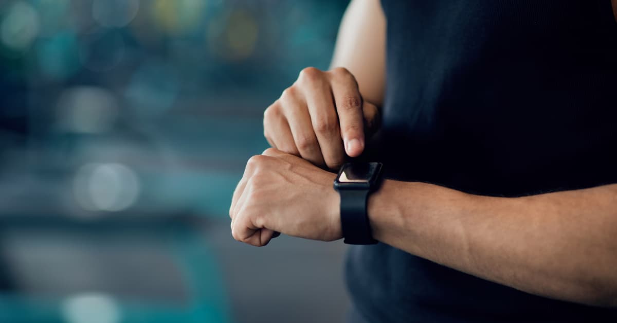 man checking his apple smart watch data in the gym