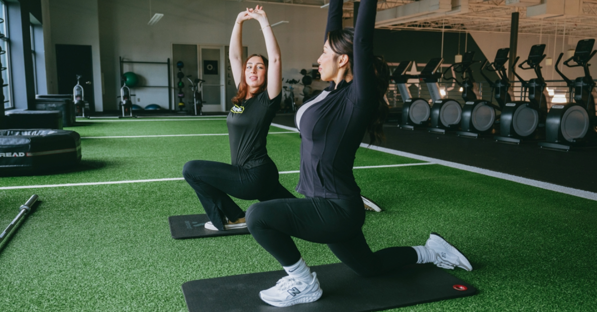 a woman and a personal trainer at o2 fitness clubs warming up on the turf 