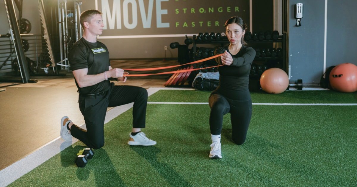 woman practicing a functional training move with a personal trainer inside o2 fitness clubs 