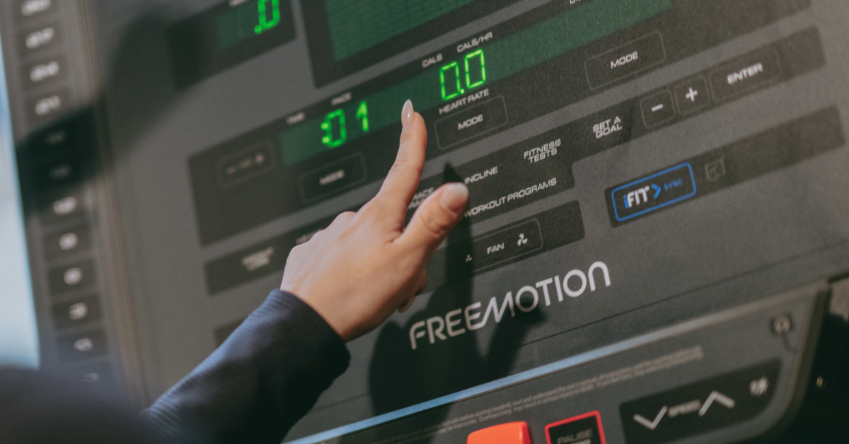 woman pressing a button to start a treadmill inside o2 fitness clubs