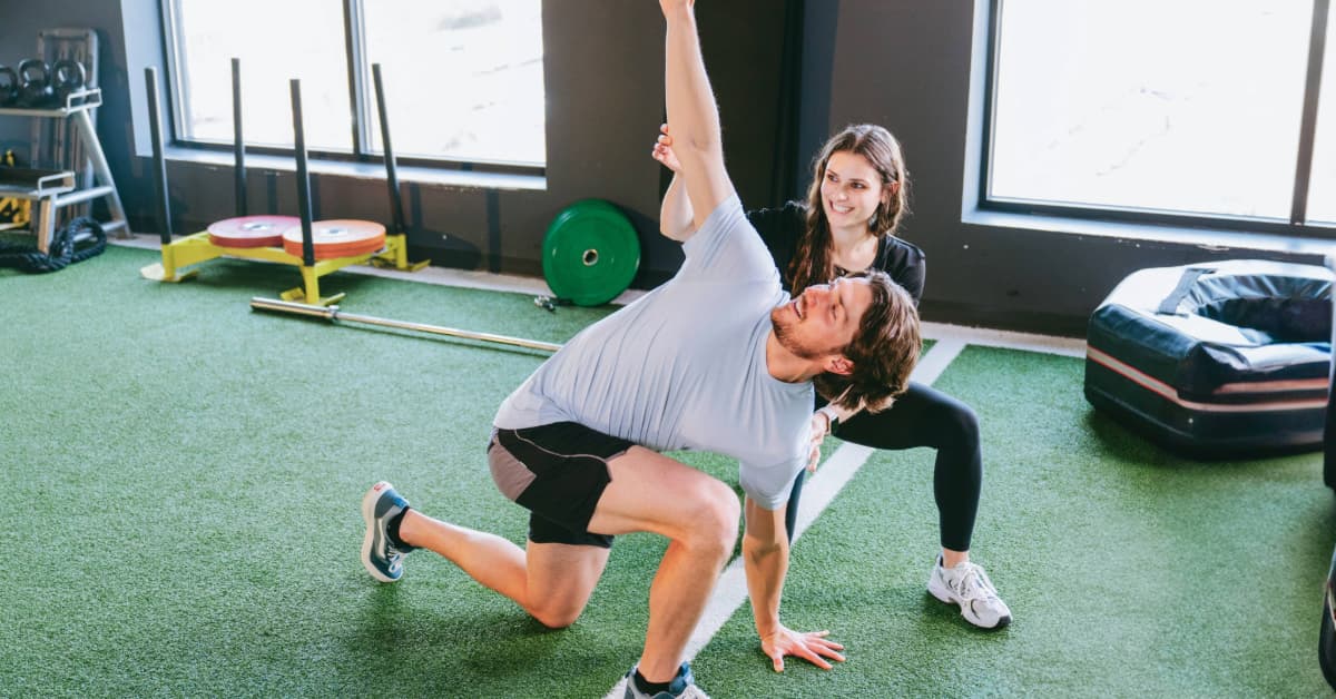 man doing dynamic stretches in a personal training session 