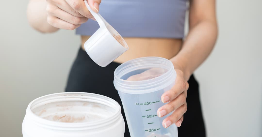 a woman preparing a protein shake