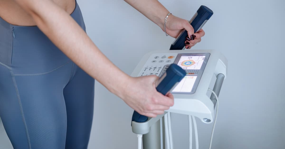 woman in blue leggings doing an inbody scan at the gym.