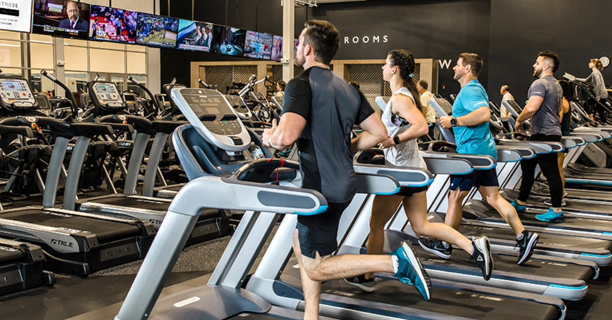 men and women running and walking on treadmills inside o2 fitness clubs